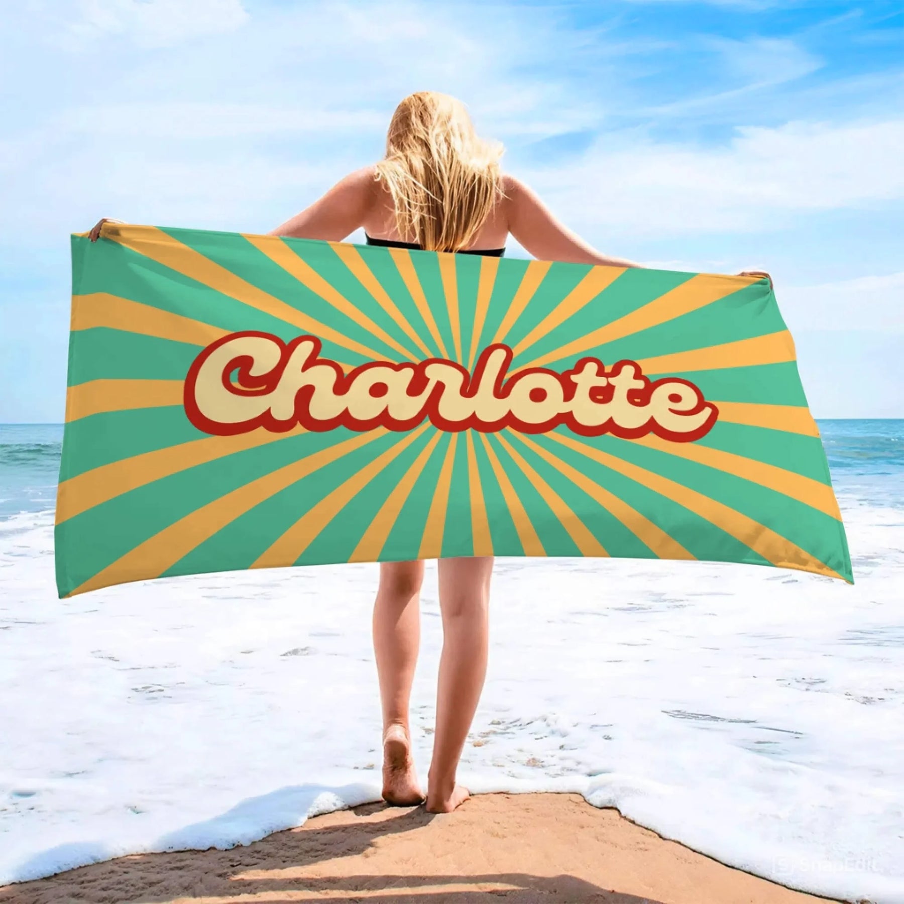 Personalized Charlotte beach towel with a vibrant retro sunburst print perfect for a beach day or summer vacation.