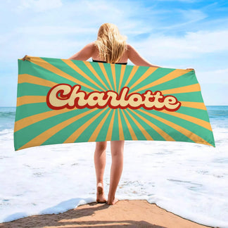 Personalized Charlotte beach towel with a vibrant retro sunburst print perfect for a beach day or summer vacation.