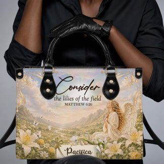 A woman holding a personalized Christian angel themed handbag that features custom name text and a beautiful floral meadow scene