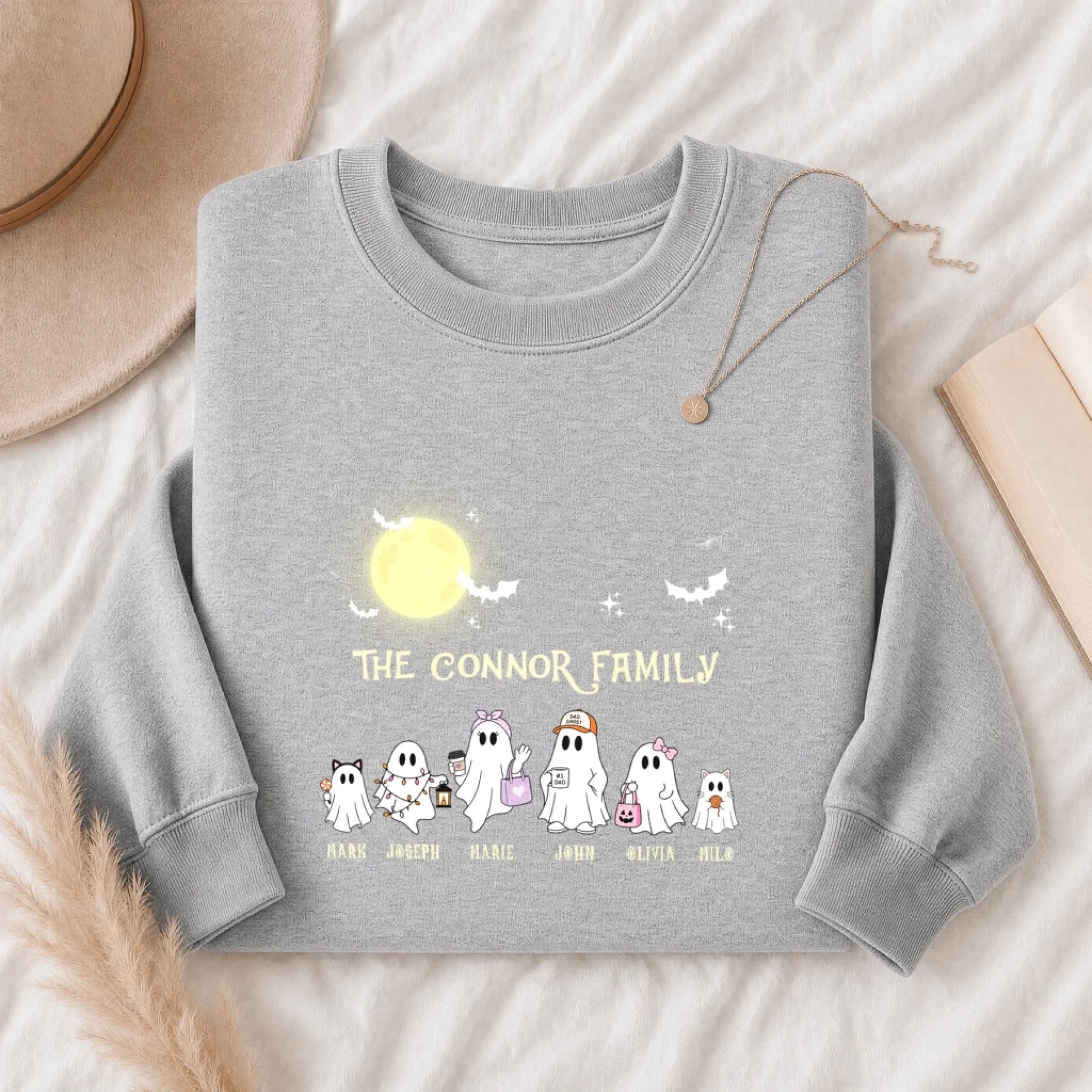 A grey personalized Halloween sweatshirt featuring a custom ghost family design with printed family member names.