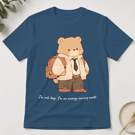 Blue t-shirt with a cartoon bear design holding a backpack on a white background