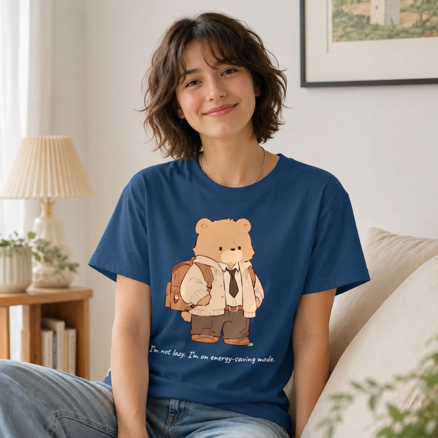 Person wearing a blue t-shirt with a bear graphic and text in a living room.
