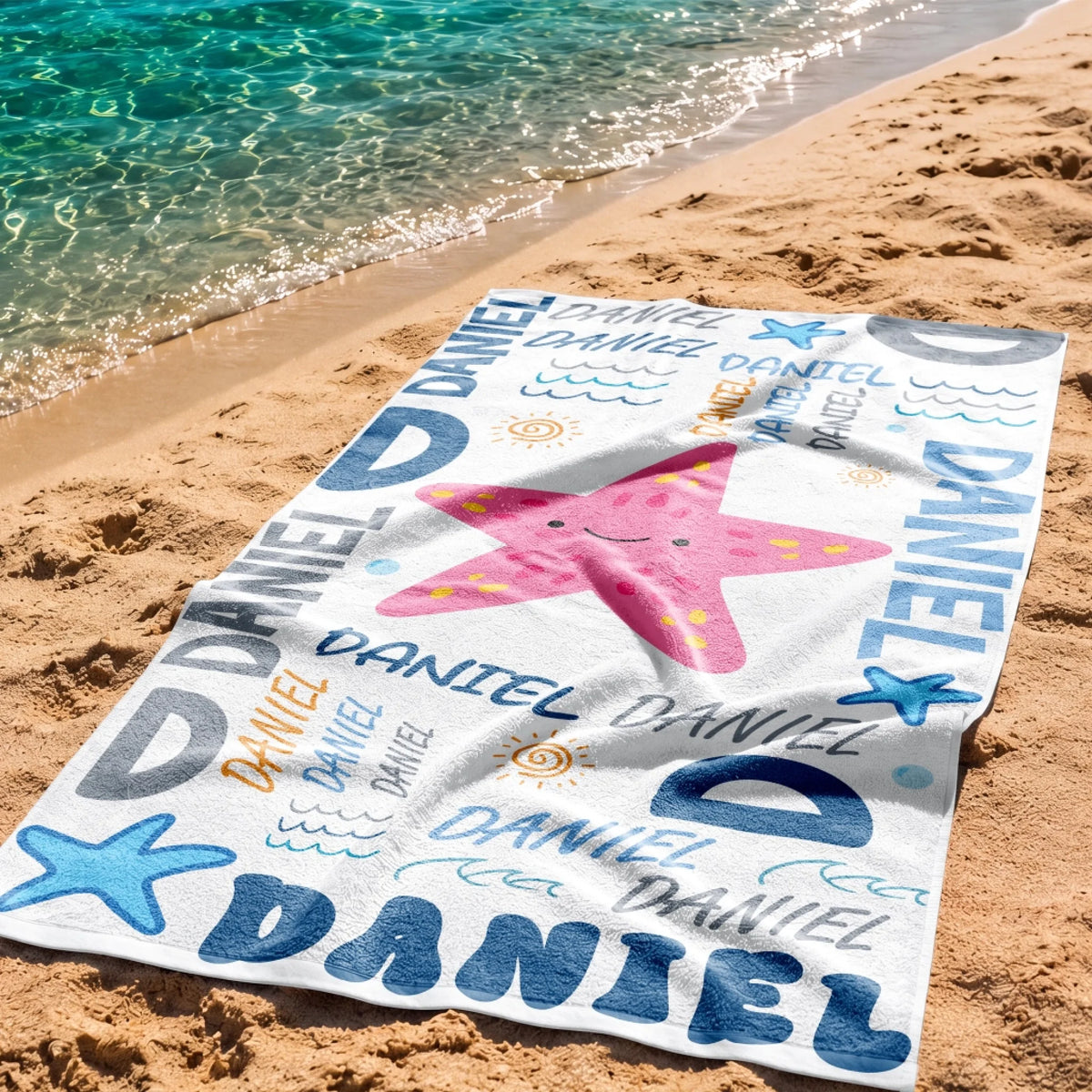 Custom name beach towel featuring a pink starfish and blue Daniel text, perfect for summer vacations and pool parties.