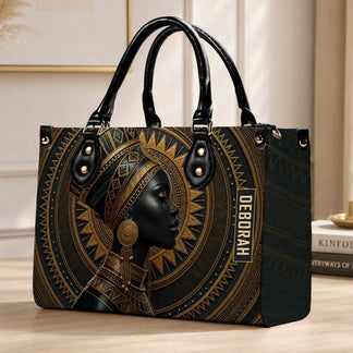 An elegant personalized handbag with African queen artistic print and the custom name Deborah on a desk setting.