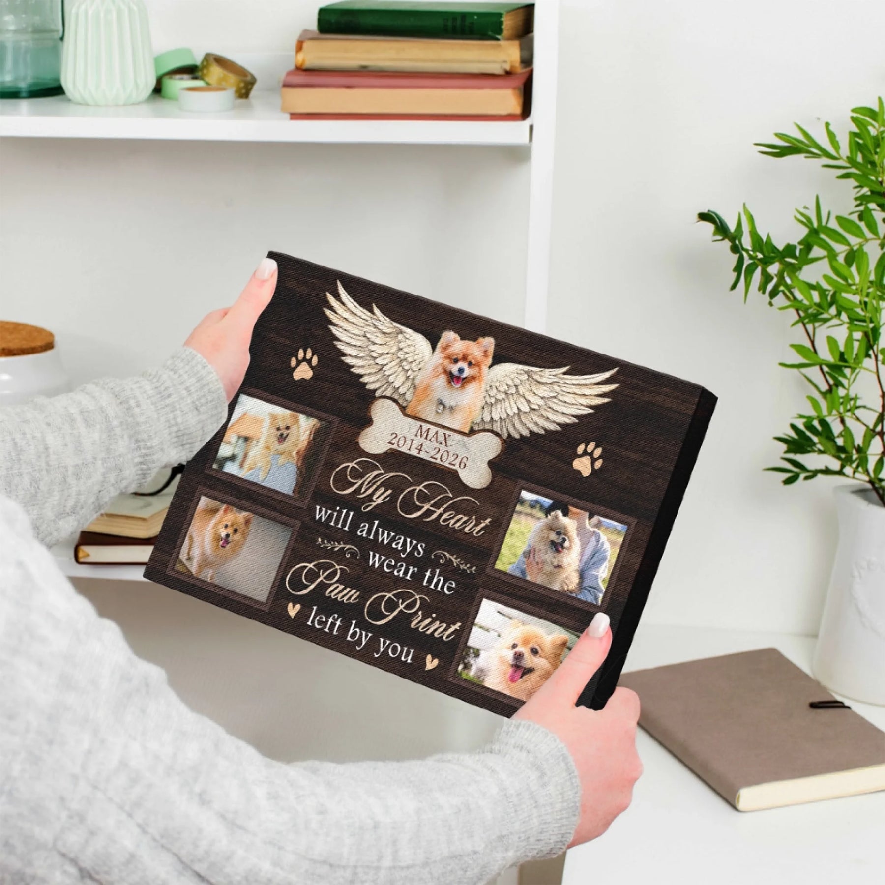 Hands holding a custom dog remembrance canvas with angel wings, photos, and a touching quote for grieving owners.