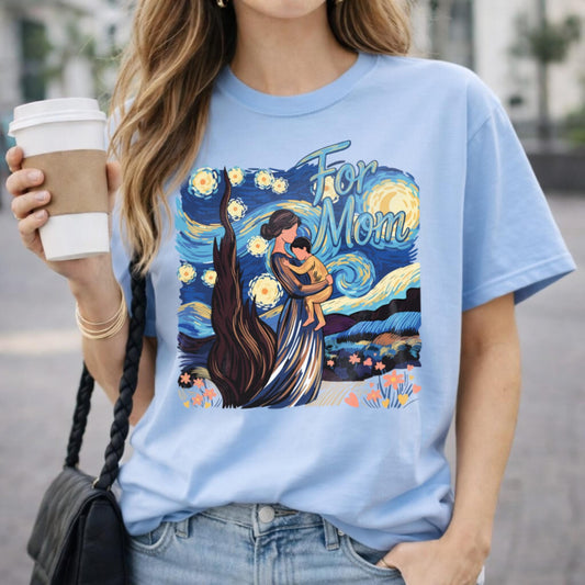 Person wearing a light blue t-shirt with a graphic design, holding a coffee cup.