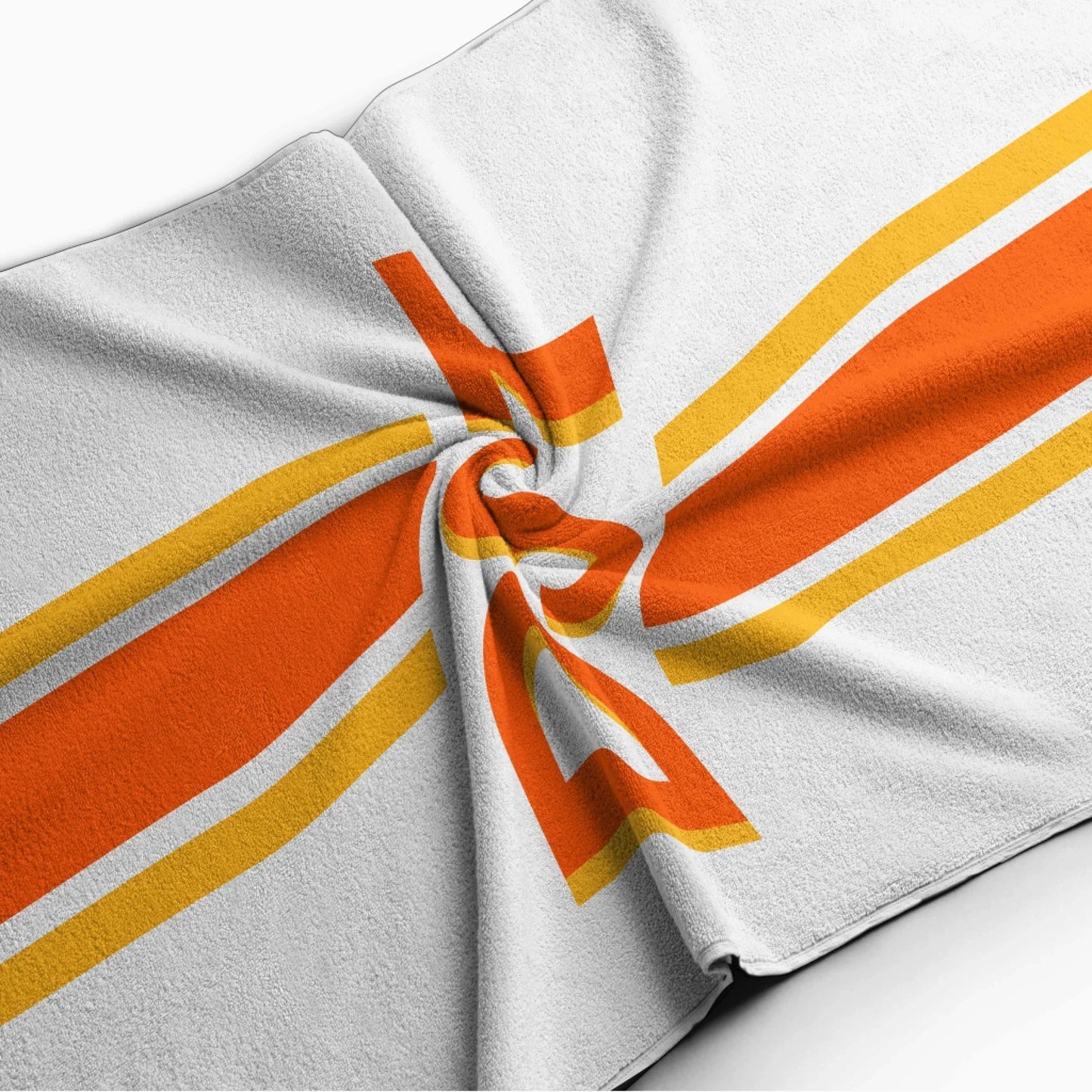 Folded personalized beach towel with a vibrant orange and yellow striped design and a custom DST monogram print