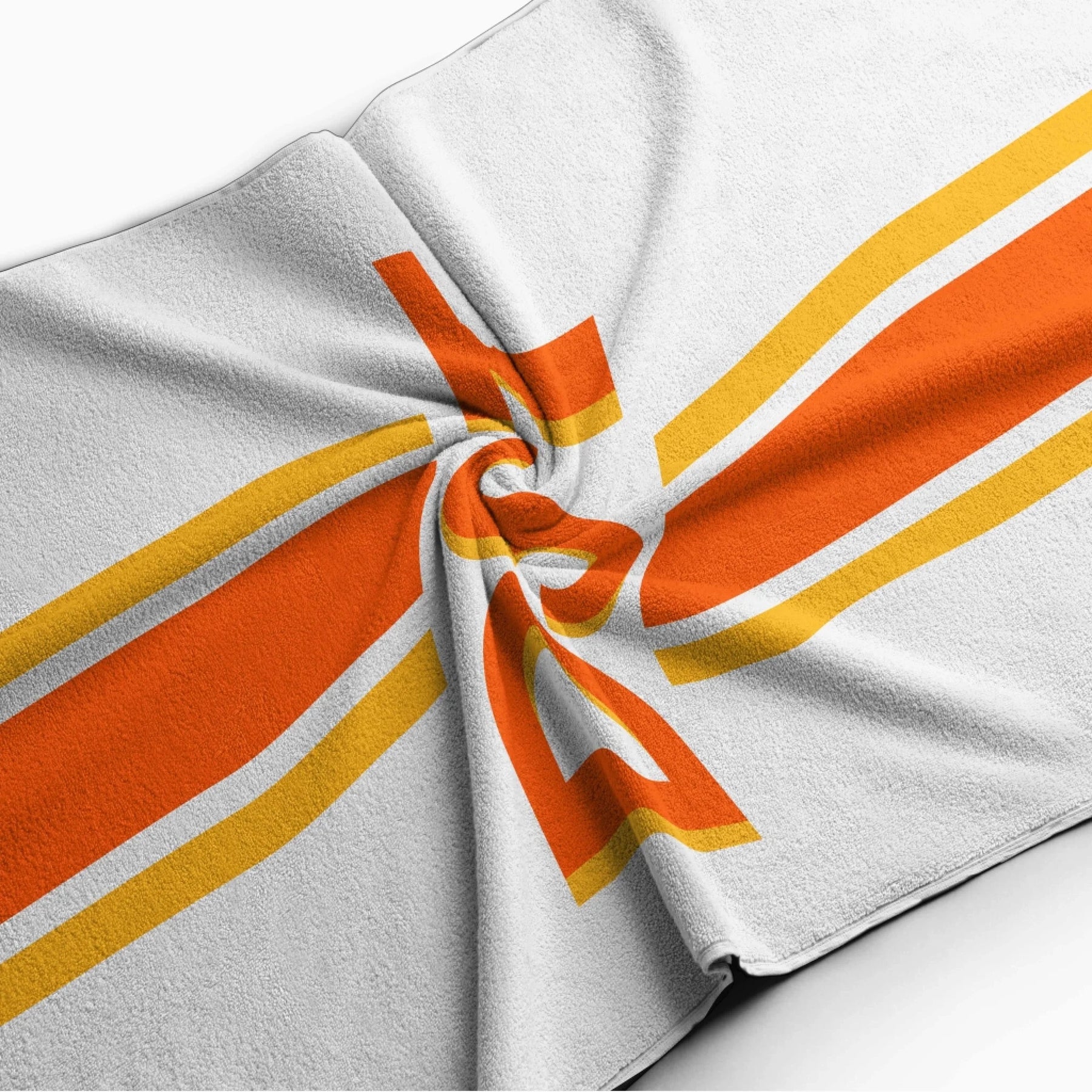 Folded personalized beach towel with a vibrant orange and yellow striped design and a custom DST monogram print