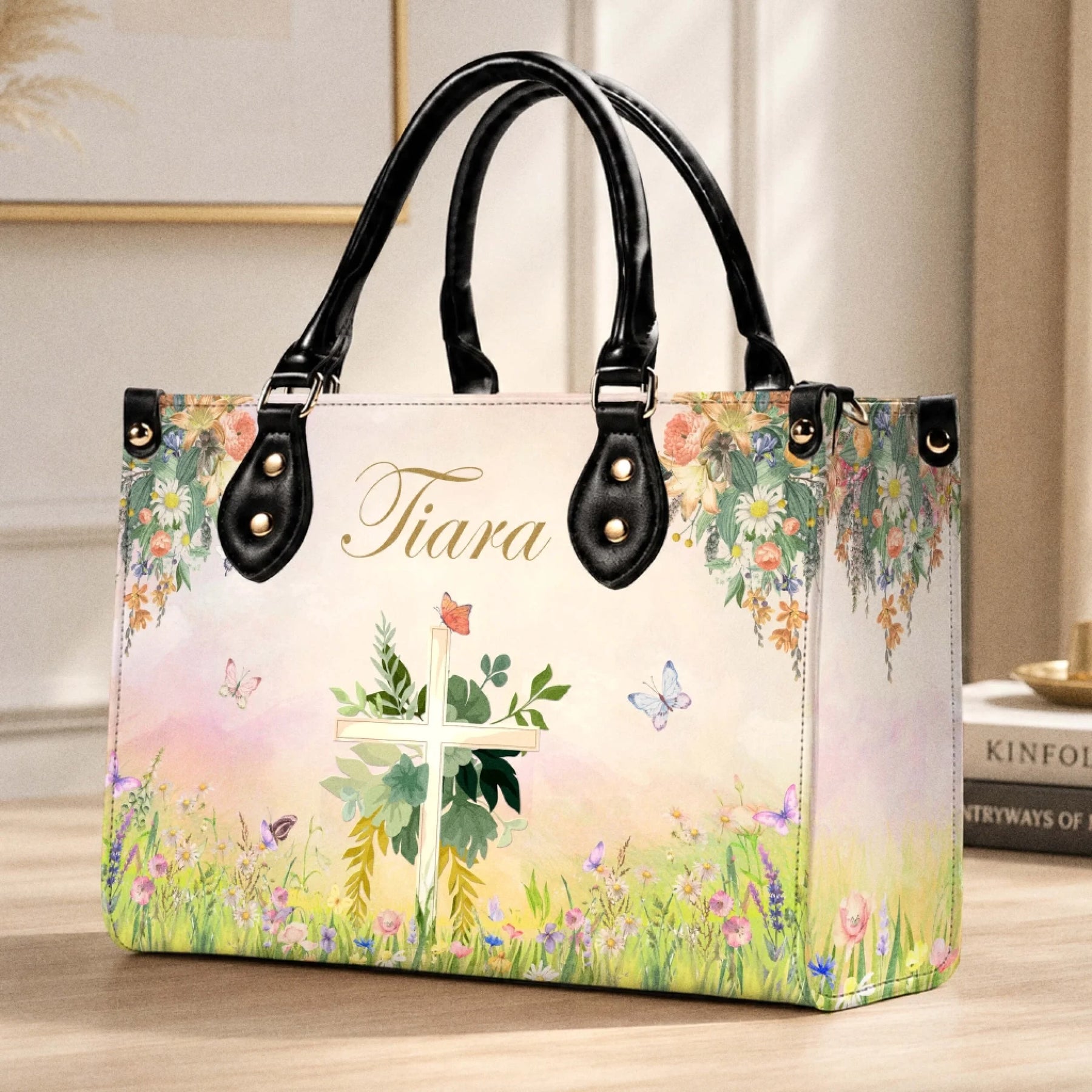 Custom floral cross and butterfly print tote bag sitting on a wooden table, ideal as a religious gift for her.