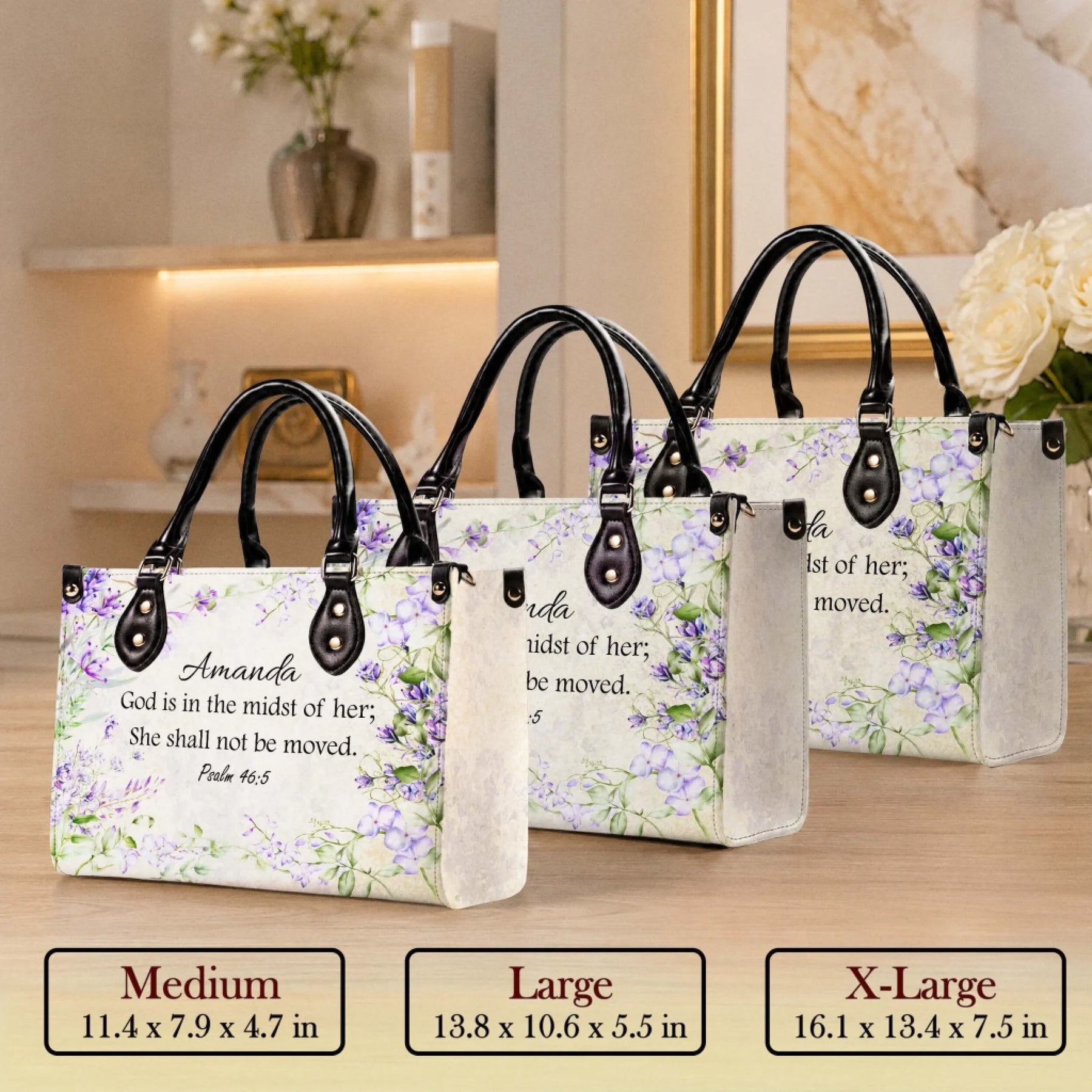 Three sizes of custom floral handbags displayed on a table for comparison, featuring Psalm 46 5 and custom name Amanda.
