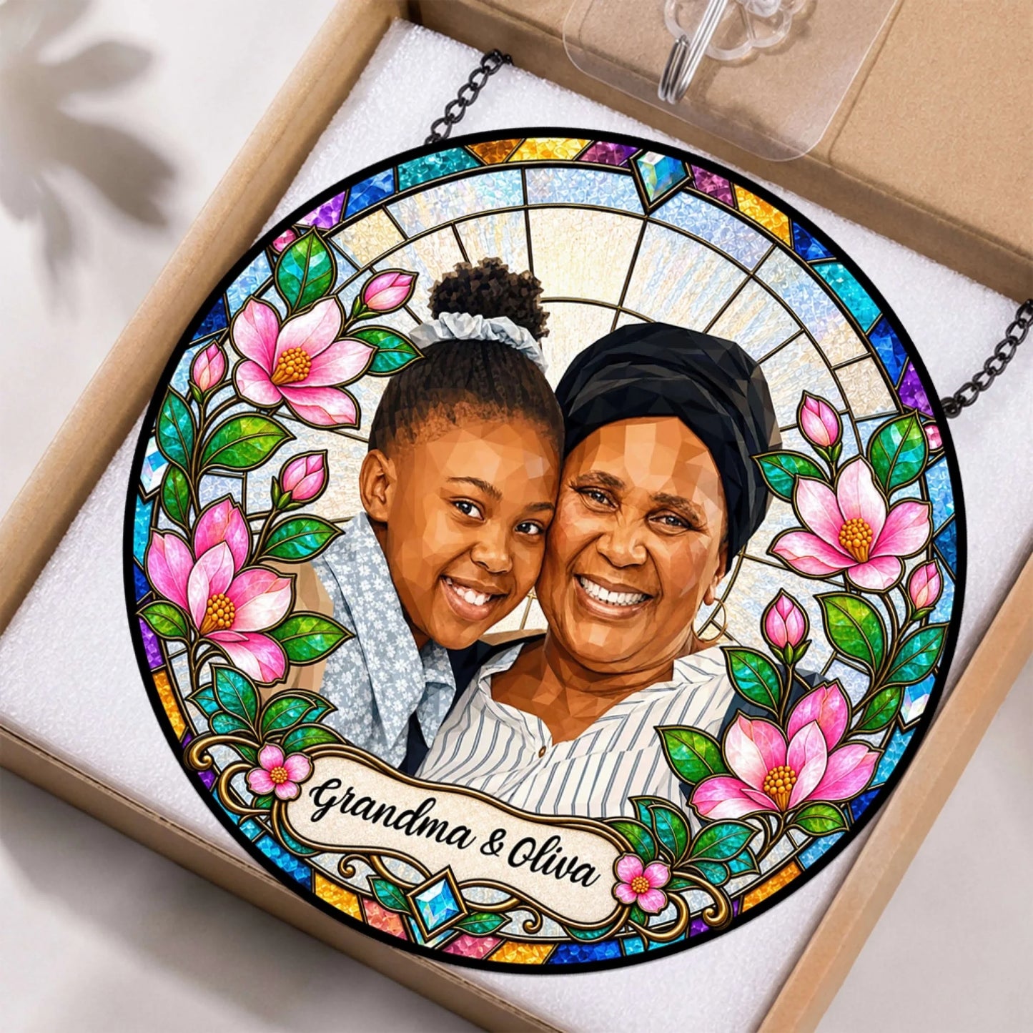 Personalized stained glass suncatcher featuring a custom photo of a grandmother and granddaughter in a decorative gift box.