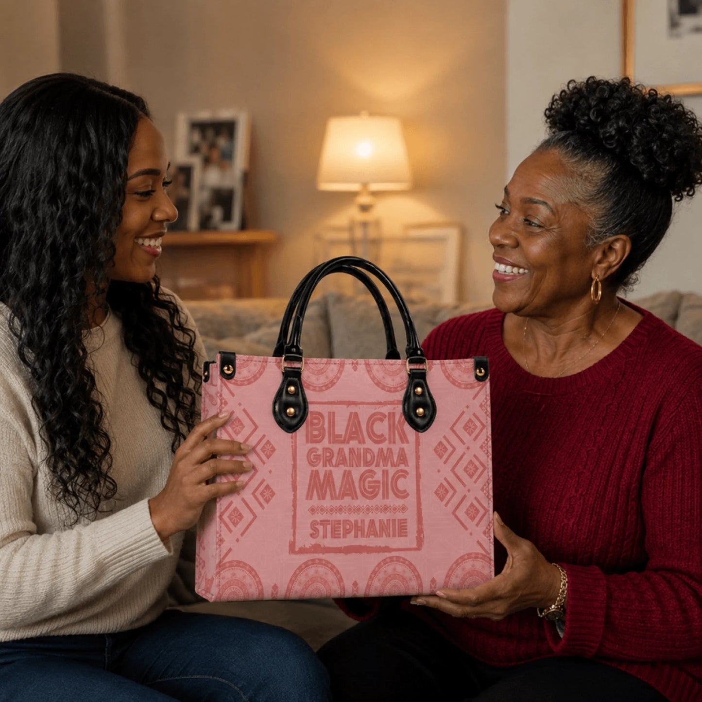 Young woman gifting a personalized pink Black Grandma Magic tote bag to her smiling grandmother