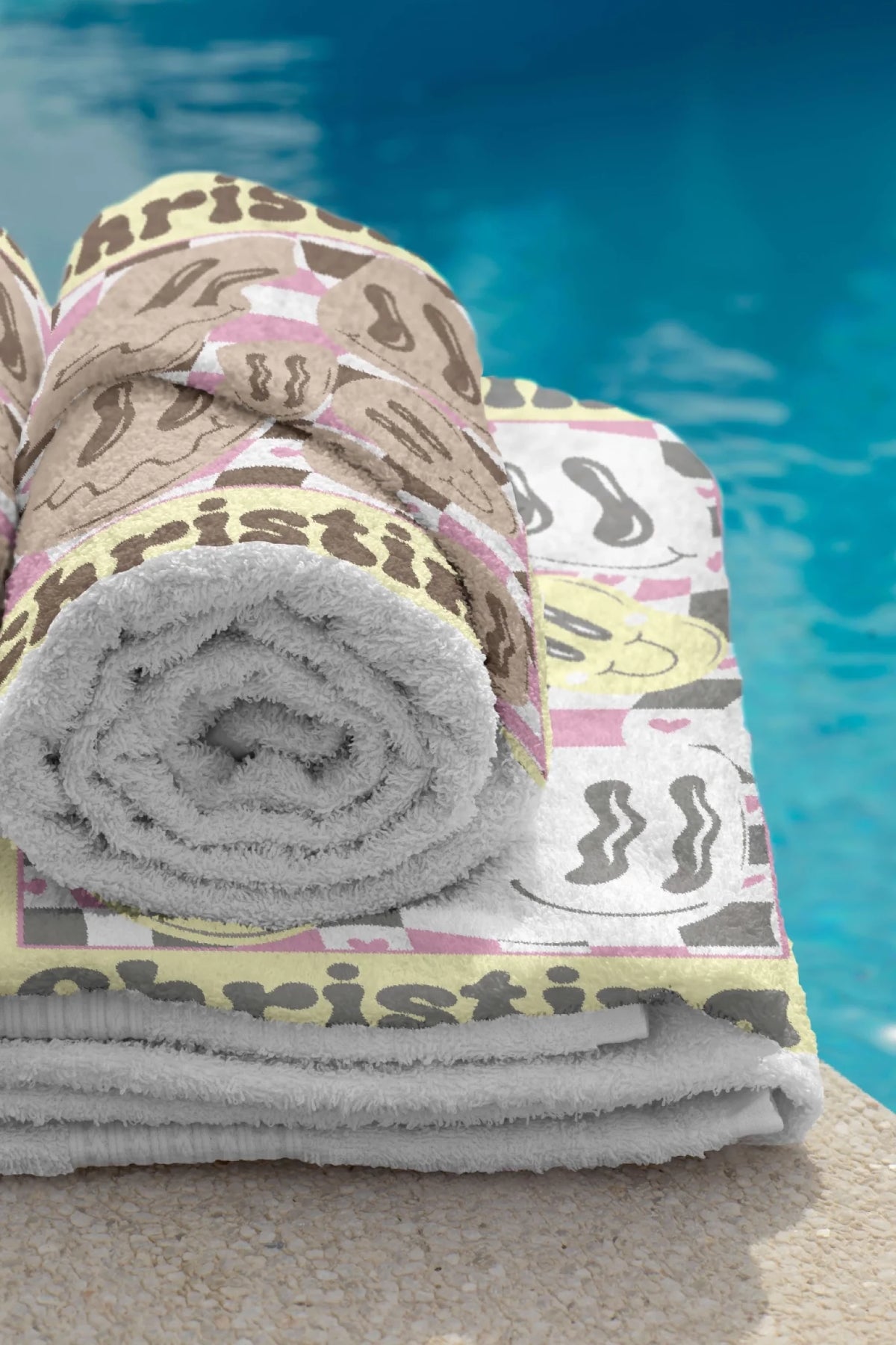 A soft personalized beach towel featuring a groovy brown and pink checkerboard background with wavy smiley faces and a custom name.