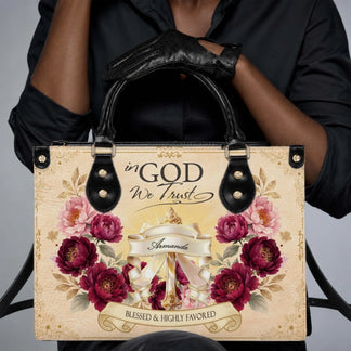 A stylish personalized PU leather handbag featuring floral designs and the inspirational religious quote In God We Trust.