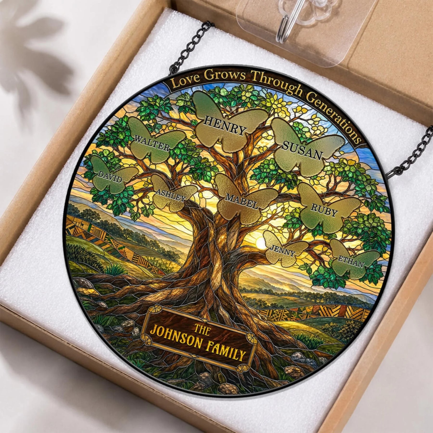 Custom family tree suncatcher in stained glass style featuring butterfly accents and the Johnson Family name, in protective packaging.