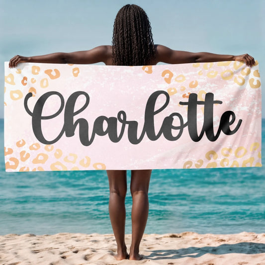 Custom name beach towel featuring a pink and gold leopard print pattern, perfect for summer vacations and beach days.
