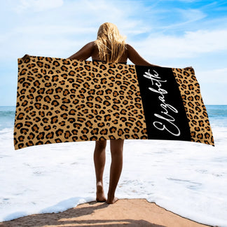 A personalized leopard print beach towel featuring the name Elizabeth written in elegant white cursive script