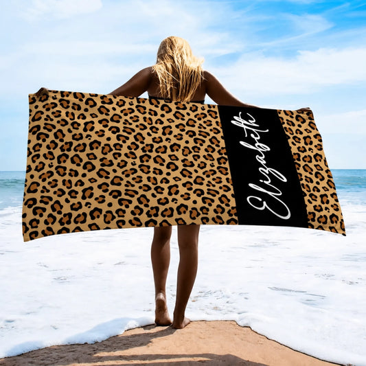 A personalized leopard print beach towel featuring the name Elizabeth written in elegant white cursive script