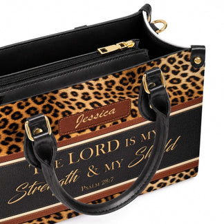 Close up of a personalized leopard print purse with a brown leather patch showing the custom name Jessica.