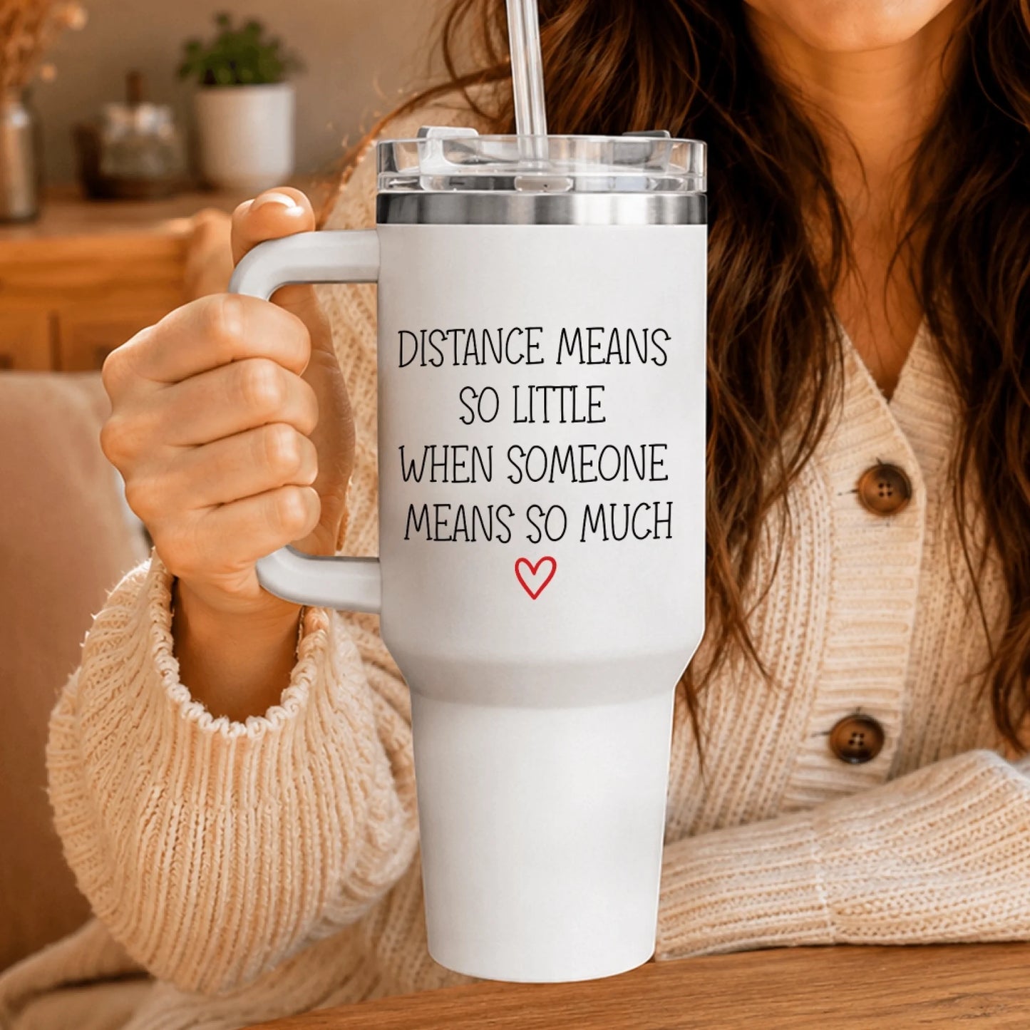 Woman holding a white personalized tumbler with the romantic quote Distance means so little when someone means so much.