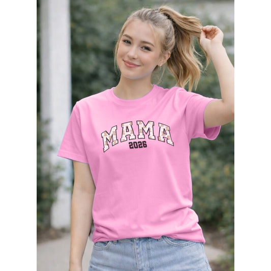 Person wearing a pink t-shirt with 'MAMA 2026' text outdoors.
