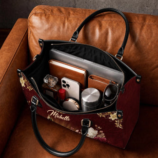 Spacious personalized Michelle religious handbag filled with daily items like a laptop, notebook, and accessories.