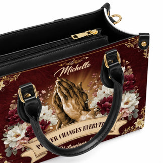 Interior view of a personalized Michelle handbag with religious praying hands design and gold tone hardware.
