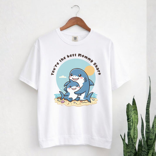 White t-shirt with shark graphic and text on a hanger against a white background