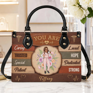 A custom nurse handbag featuring inspirational text including caring and strong with a floral character illustration.