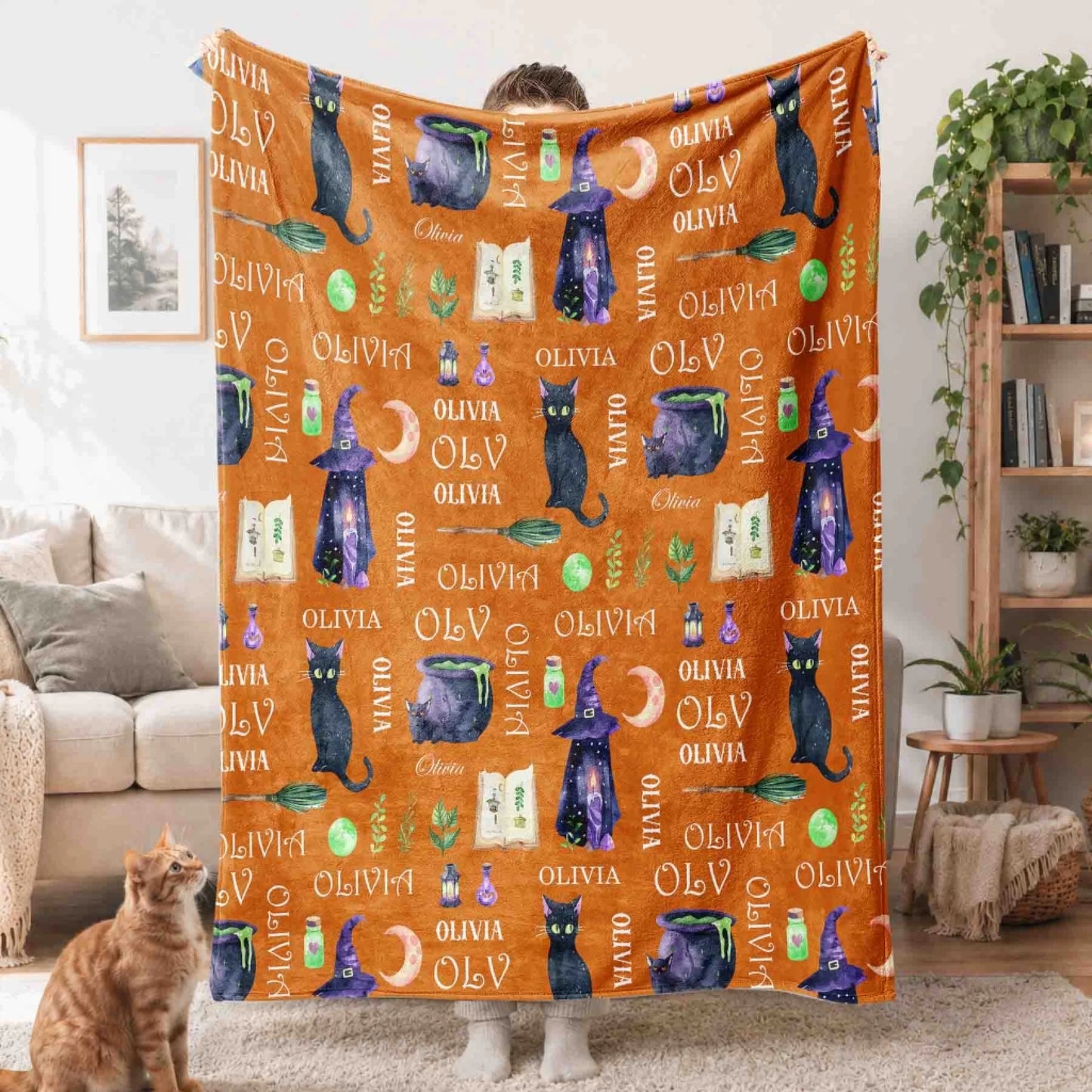 Orange personalized Halloween throw blanket with black cats and witch motifs, perfect for custom autumn home gifts.