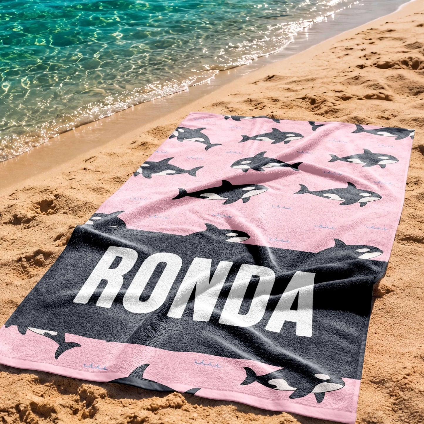 Custom beach towel with a pink background and orca whale print personalized with the name Ronda for ocean fans.