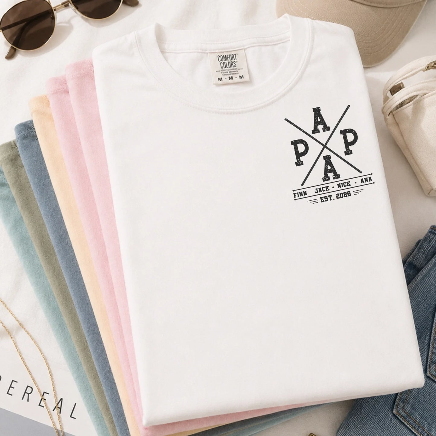 Folded white personalized Papa t-shirt with fishing graphics and custom kids names, perfect as a Father's Day gift.