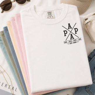 Folded white personalized Papa t-shirt with fishing graphics and custom kids names, perfect as a Father's Day gift.