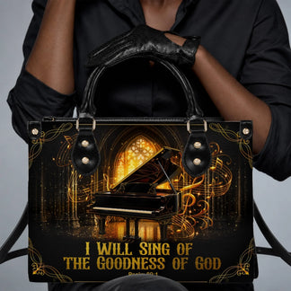 Personalized black handbag featuring a grand piano design and the quote I Will Sing Of The Goodness Of God in gold.