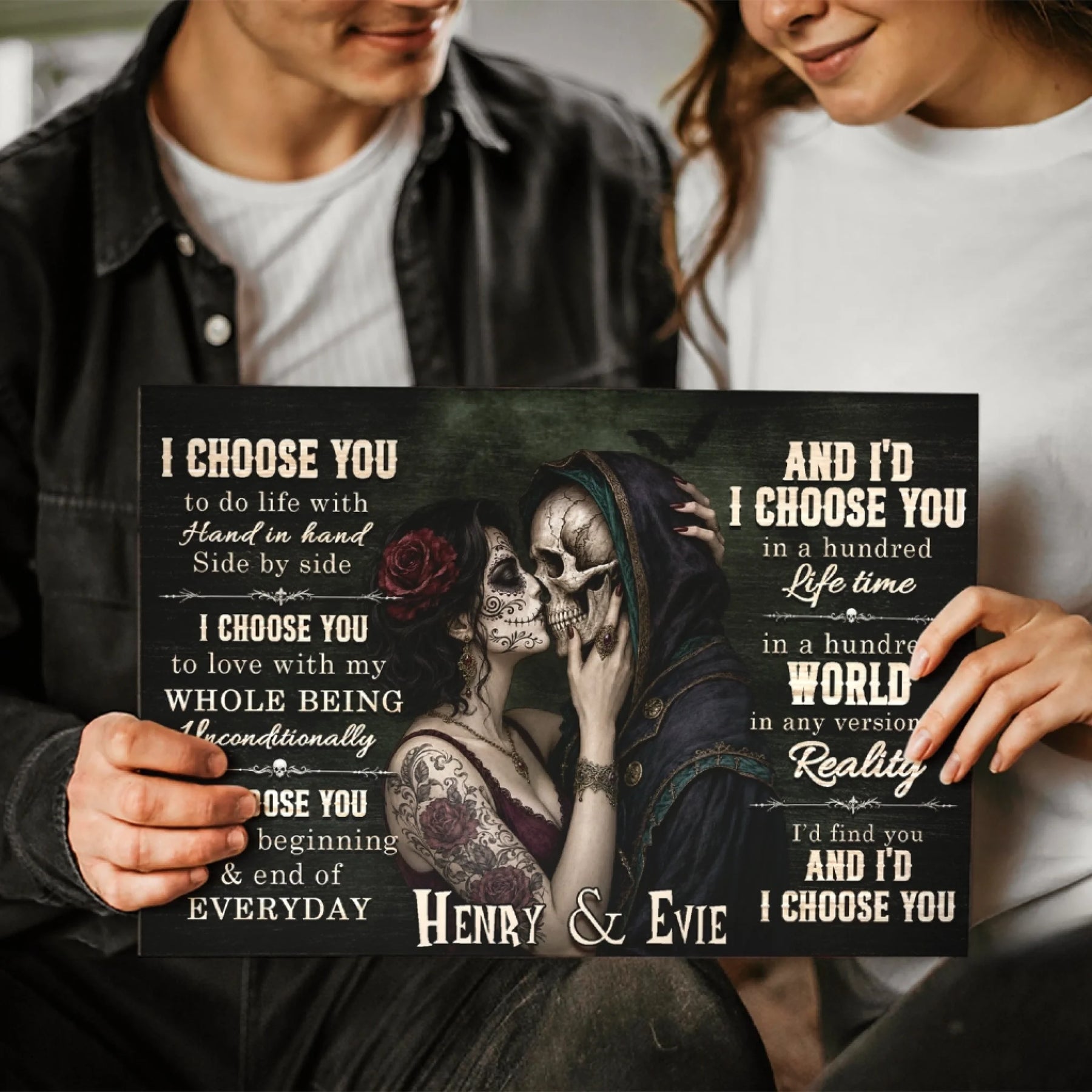 Couple holding a personalized sugar skull canvas wall art printed with the names Henry and Evie for a romantic gift.