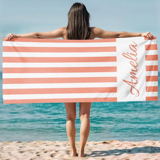 Custom peach striped beach towel with the name Amelia displayed, perfect for a sunny day at the ocean or pool.