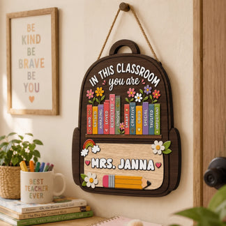 A personalized wooden backpack wall hanging for teachers with classroom affirmations, flower details, and 'Mrs. Janna'.