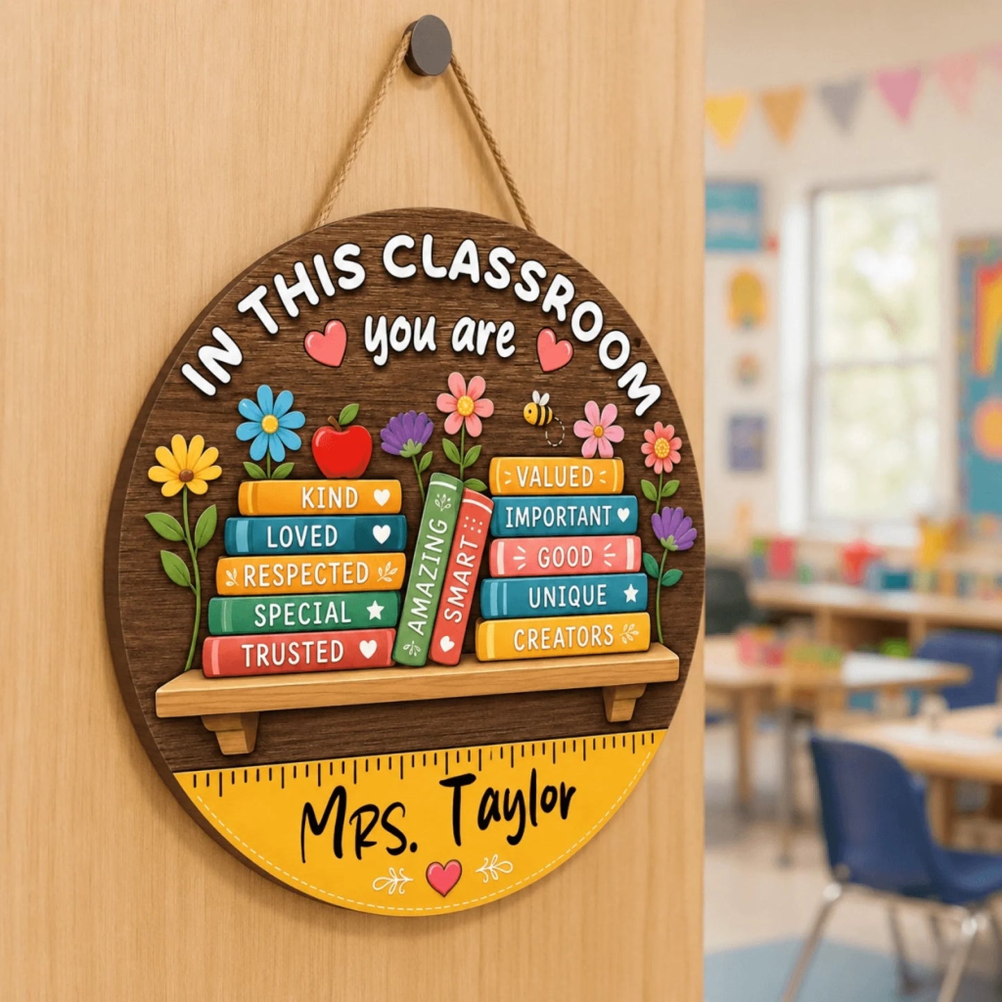 Round wooden classroom sign hanging on a door, customized for Mrs. Taylor with books labeled kind, loved, and valued.