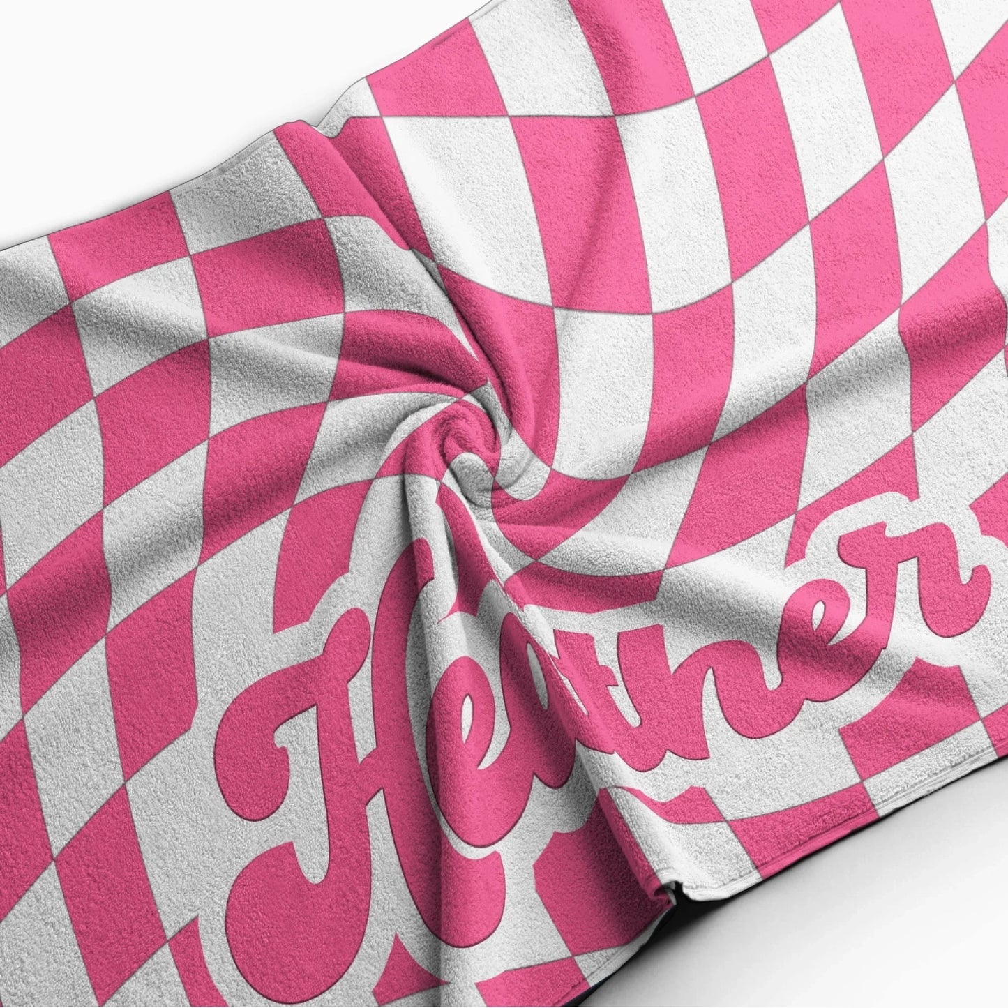 Close up of a personalized beach towel with a groovy pink and white distorted checkerboard pattern and custom name.