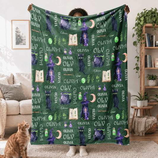 Cozy personalized Halloween fleece blanket featuring a black cat witch hat and cauldron pattern with custom name Olivia.