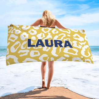 Woman showcasing a yellow and white leopard print beach towel with the custom name Laura, perfect for a personalized summer gift.