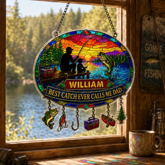 Stained glass panel with fishing scene and 'William' name, hanging by a window with a view of a lake.