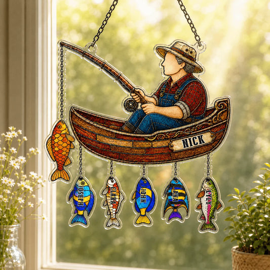 Decorative hanging sign with a fisherman in a boat and colorful fish below, on a window sill.