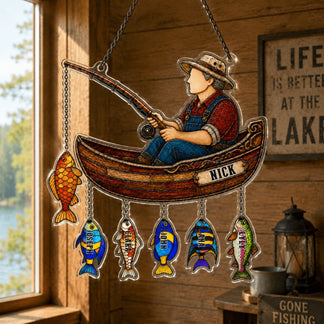 Decorative hanging sign with a fisherman and fish near a window with a view of water.