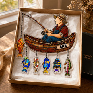 Decorative wall art of a boy fishing in a boat with colorful fish below, in a box.