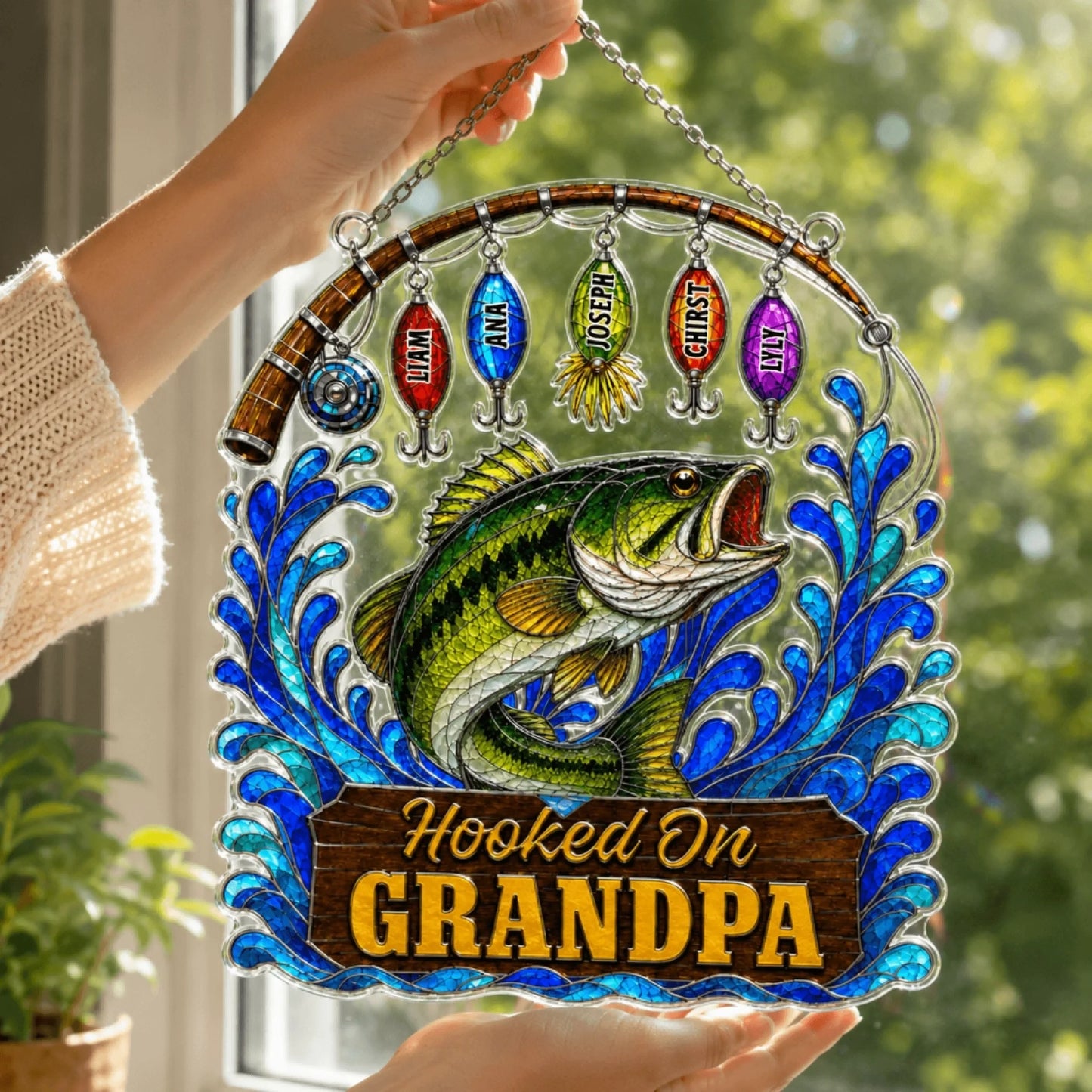Decorative stained glass panel with a fish and 'Hooked On Grandpa' text, held by a hand.