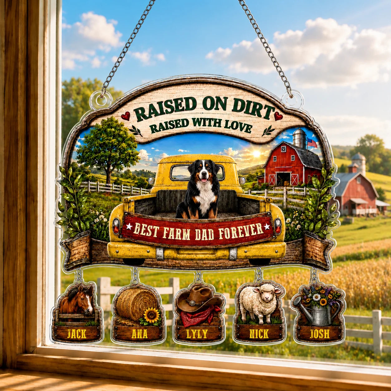 Decorative sign with a farm scene, truck, and animals hanging on a window.
