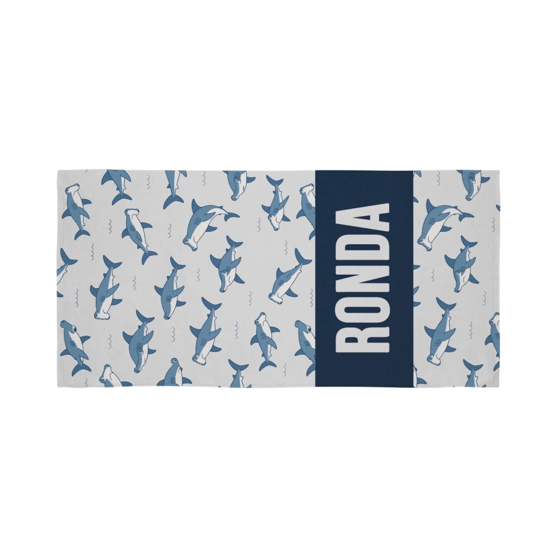 Personalized beach towel featuring a light gray hammerhead shark pattern and a bold navy blue section with the name Ronda.