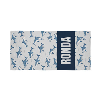 Personalized beach towel featuring a light gray hammerhead shark pattern and a bold navy blue section with the name Ronda.