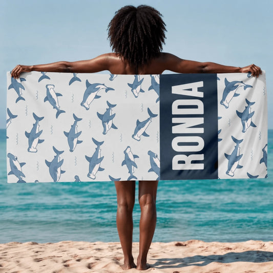 A personalized beach towel featuring a cute shark pattern and the name Ronda printed in large bold white letters.